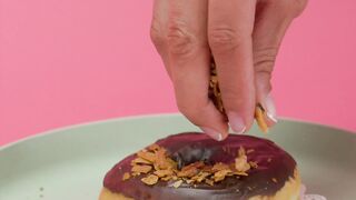Spreading Toasted Coconut Chunks on a Donut