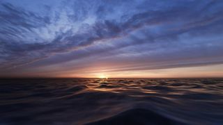 Sunset behind the waves of the sea