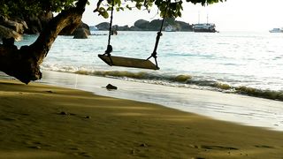 Rope swing on the beach at sunset