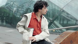 a-young-man-sitting-on-a-bench-using-his-smartphone