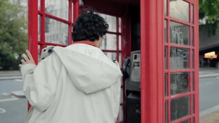 a-young-man-enters-a-red-telephone-box