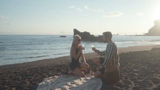 a-loving-couple-clinking-wine-glasses-at-the-beach