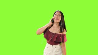 Girl dancing with her earphones on a green background