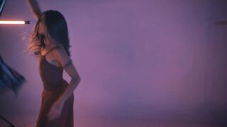 Young woman dancing and spinning in a dark studio