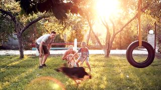 Family playing with a dog in the garden