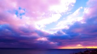 Clouds colored in pink and violet in the sunset