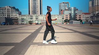 Young man walking listening to music from his headphones