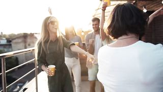 Cinematic of friends dancing on terrace party