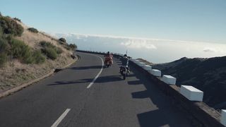 Bikers driving at a high altitude close to a mountain peak