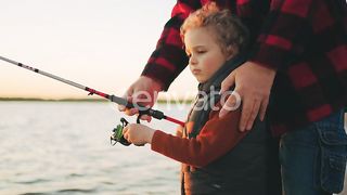 Curly Little Boy Learns the Art of Fishing: A Tender Bond Between Father or Grandpa and Son, Crafting Memories of a Joyful Childhood
