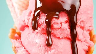Strawberry ice cream cone with chocolate syrup on a blue background