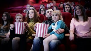 Family Movie Night: A Heartwarming Medium Shot of Joy and Togetherness at the Cinema