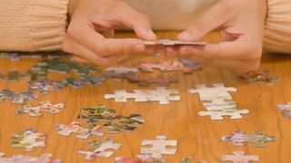 Person putting together a big puzzle