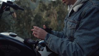 A motorcyclist taking his gloves off
