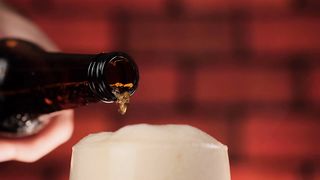 Pouring beer into a glass while the foam overflows