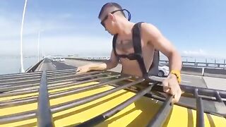 An extreme man jumped from a bridge with a parachute from the roof of a moving car