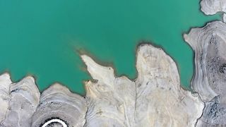 Azure Serenity: A Captivating Aerial Perspective of a Blue Lake and Majestic Mountains