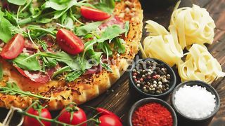 Taste of Italy: A Delectable Italian Food Spread with Pizza, Fresh Pasta, and Vibrant Vegetables on Rustic Wooden Table