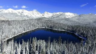 Drone Flying Over Snow-Covered Lake: A Winter Wonderland Aerial Expedition