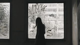The Haunted Gaze: A Scary Woman Peering Through the Window