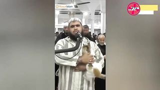 the cat climbs onto the imams shoulders during prayer