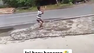 small children dancing on the side of the road