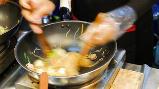 Asian stir-fried noodles cooking in pan