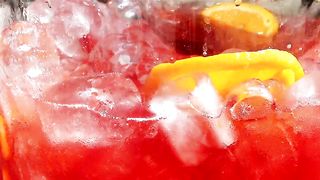 Close up of an ice jug of fruit punch being stirred