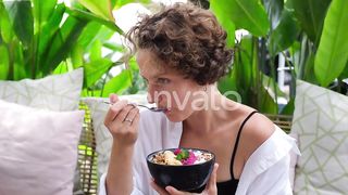 Curly Girl Tasting Tropical Fruit Breakfast in Ceramic Bowl Sitting in Hotel Enjoying Exotic Healthy by Life_Music on Envato Elements