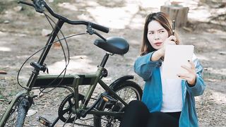Happy-asian-beautiful-young-woman-riding-bicycle-on-street