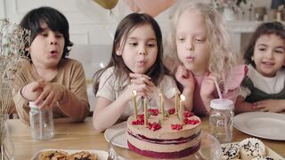 Kids Blowing the Candles in the Birthday Cake