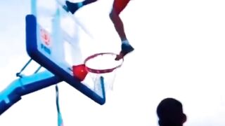 basketball player performing a slam dunk trick