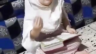 Cute baby reading a Quran pak