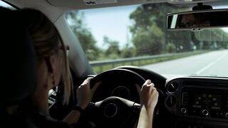 Blonde woman driving on road