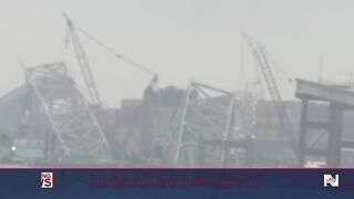 Workers create narrow channel through destroyed Baltimore bridge.