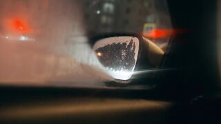 view of City Traffic at Night through Car's Side View Mirror