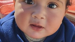 A cute baby Muhammad Ahmed coughing and playing with Mama