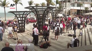 Eclipse spectators in Mexican resort town stake out their spots.