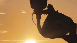 Silhouette of a lighthouse during sunset - AdalineTV