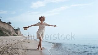 Happy girl standing on a sandy beach