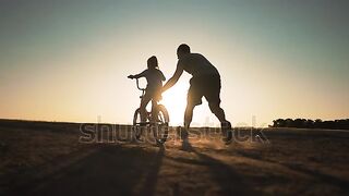 Happy family. Father teaches daughter to ride bike in park????