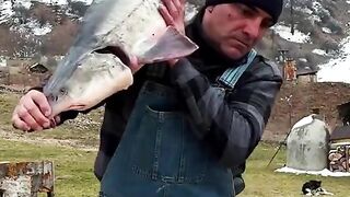Cooking biggest beluga in huge metal barrel.