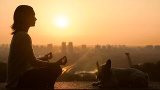 A woman doing meditation with her Pet pet.
