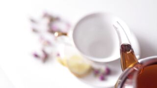 Top view of teapot pouring tea into china cup - adalinetv