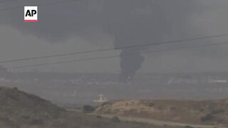 Large smoke plume climbs into sky over Gaza Strip.