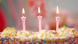 Putting out candles on a colorful cake