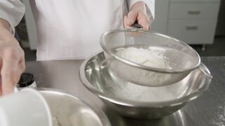 Professional pastry chef adding flour for a cake