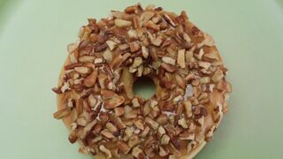 Donut with nut rotating on a pastel green background