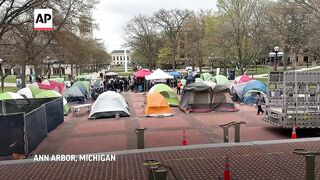 Israel supporter stands near pro-Palestinian encampment at University of Michigan.
