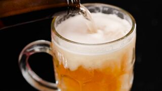Filling a mug with beer on a dark background